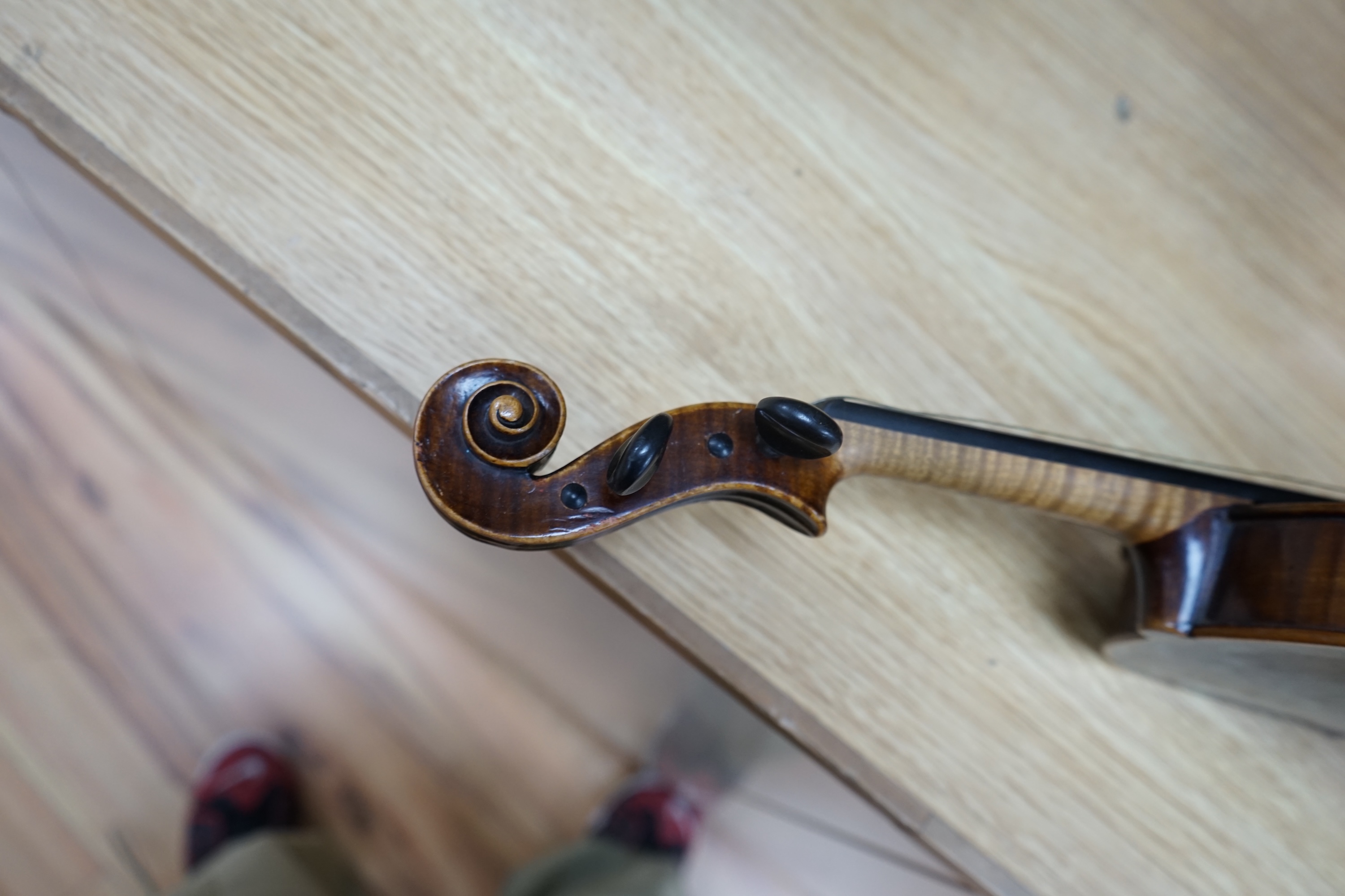 An early to mid 20th century violin, interior label reads ‘Copy of Antonius Straduarius made in Germany’, cased with bow, back measures 33.5cm. Condition - fair to good